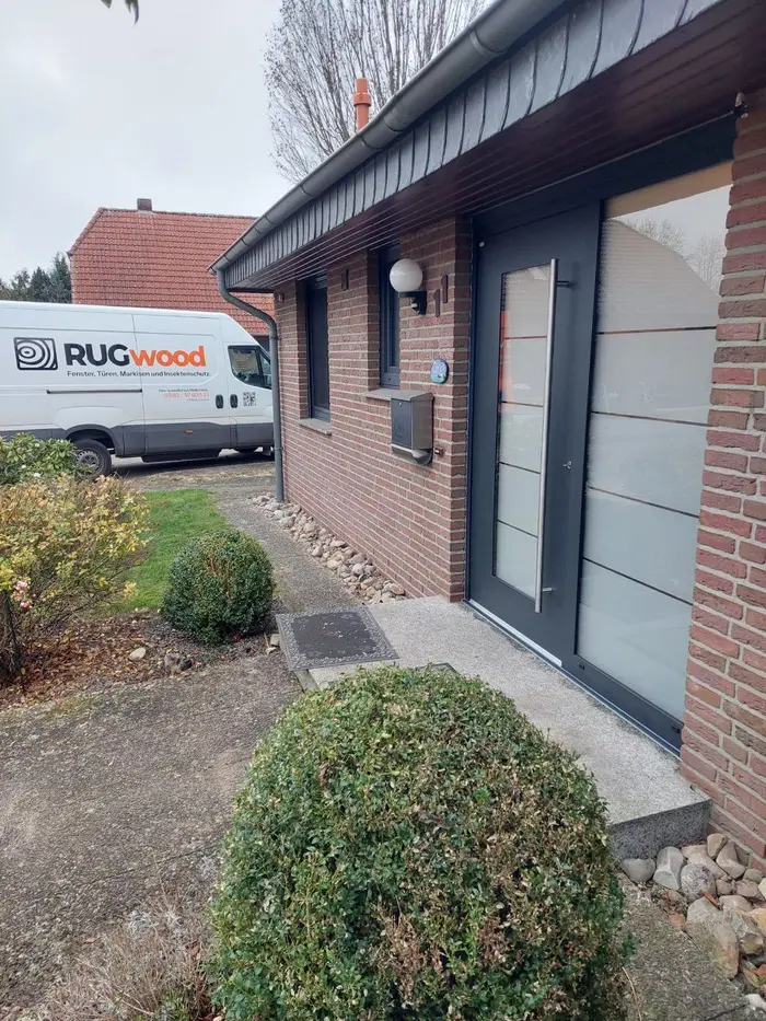 RUGwood-Montagefahrzeug vor einem Einfamilienhaus mit neu montierter Haustür