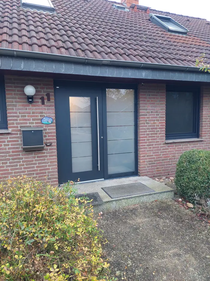 Anthrazitfarbene Haustür mit Seitenteil in einem Klinker-Eingangsbereich