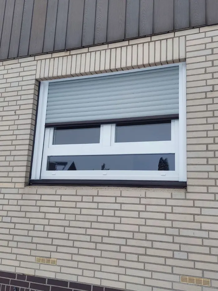 Fenster mit Vorbau-Rollladen an einer hellen Klinkerfassade